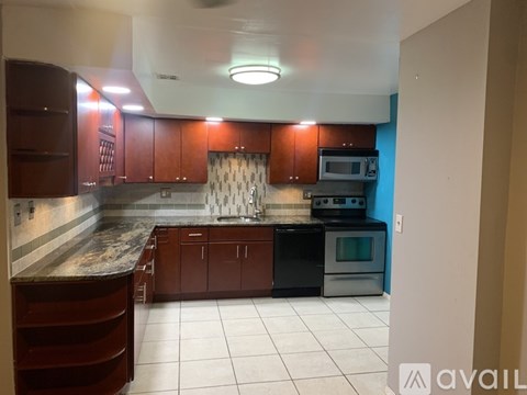 A kitchen with brown cabinets and a black oven.