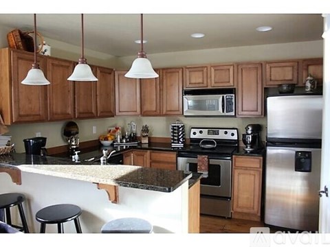 A kitchen with wooden cabinets and a granite countertop.