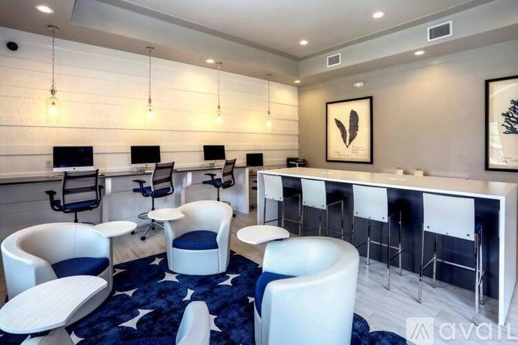 A modern office space with white and blue chairs and desks.