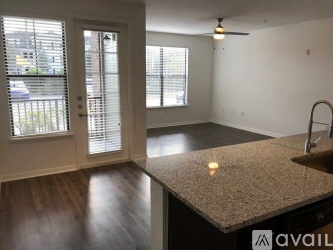 A kitchen with a granite countertop and a ceiling fan.