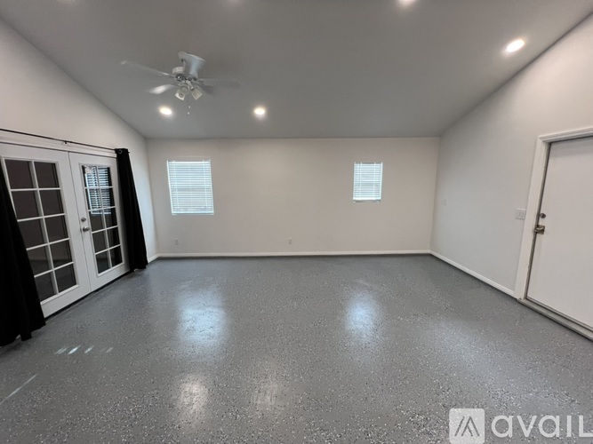 A room with a white door and a ceiling fan.