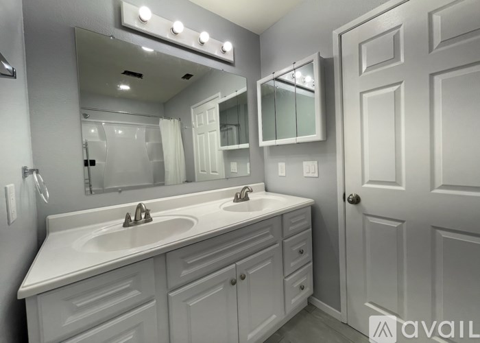 A bathroom with a white sink and cabinets.