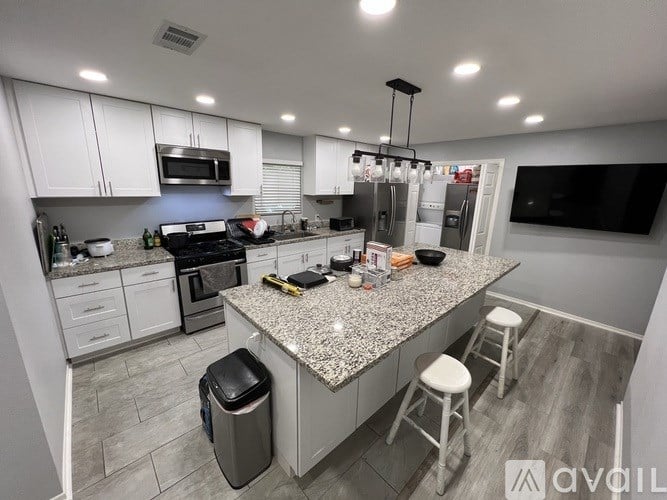 A kitchen with granite countertops and white cabinets.