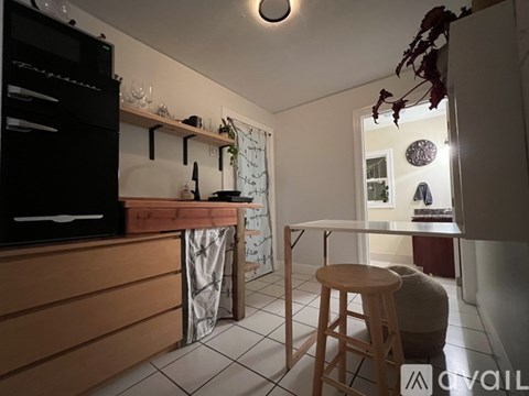 A kitchen with a wooden counter and a bar stool.