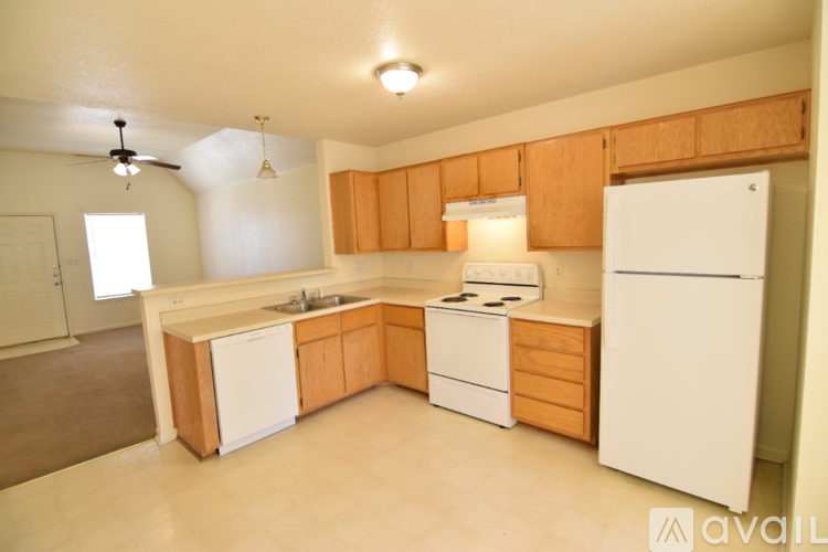 A kitchen with wooden cabinets and white appliances.
