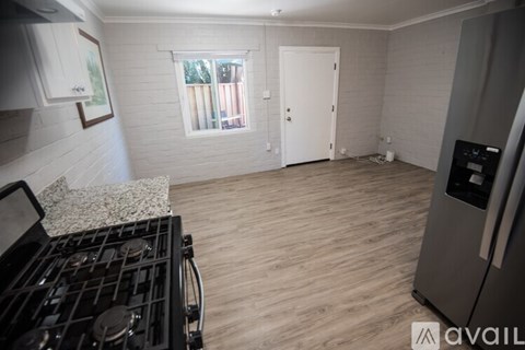 A kitchen with a stove top oven and a fridge.