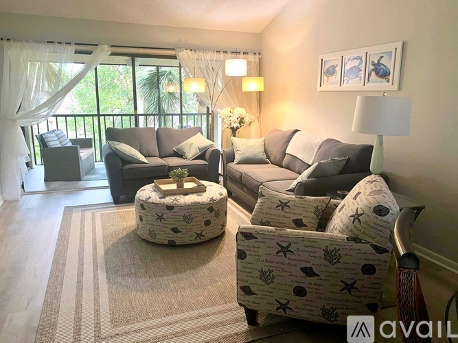 A living room with a couch, chair, and ottoman.