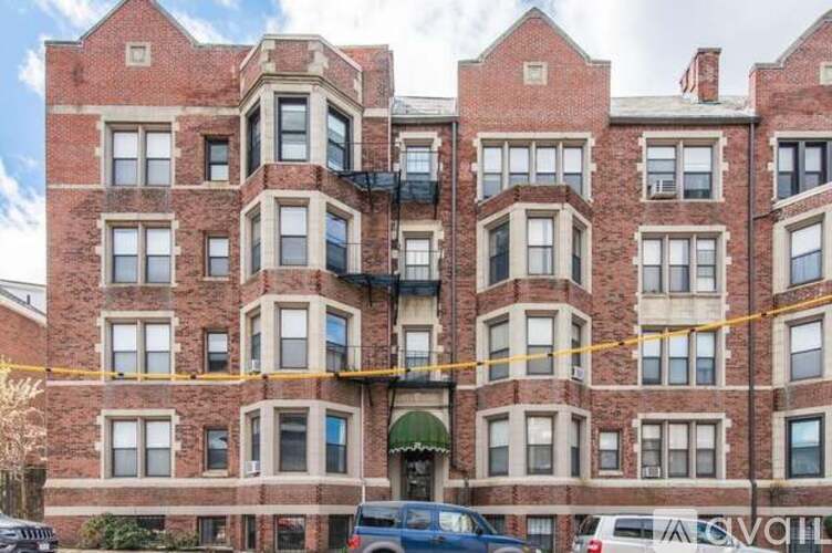 A red brick building with a yellow line in front of it.
