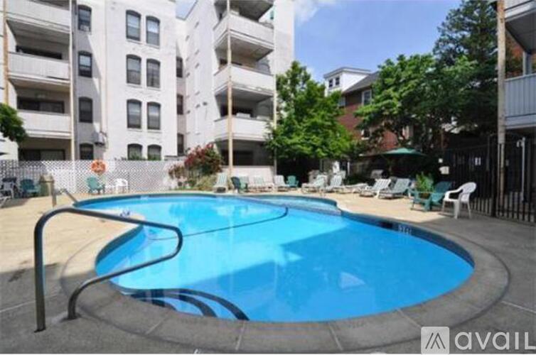 A swimming pool in a residential area with apartment buildings in the background.