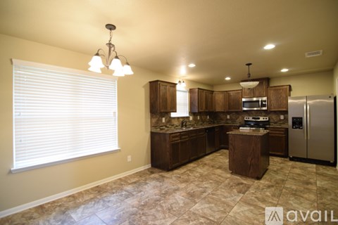 A kitchen with wooden cabinets and a refrigerator.
