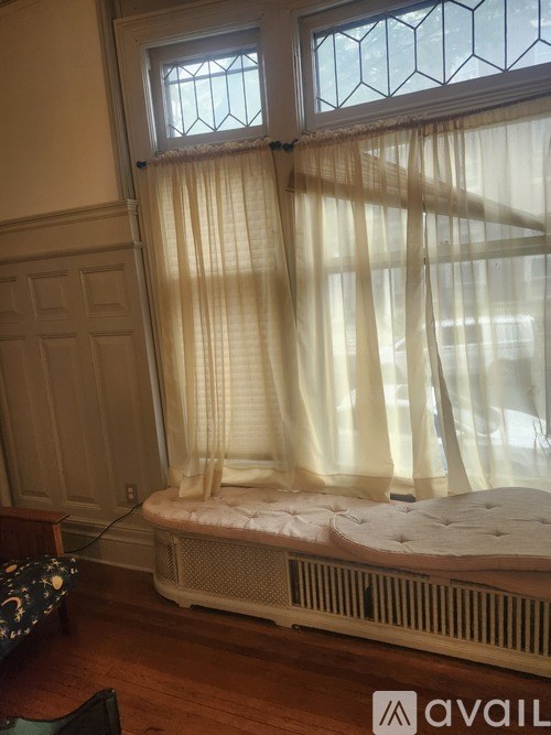 A bedroom with a bed and a window with curtains.