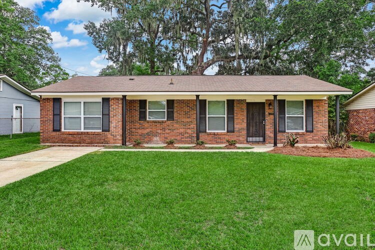 A house with a brown roof and brick walls is for sale.
