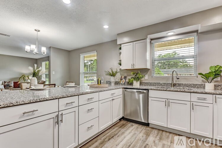 A kitchen with white cabinets and a granite countertop.