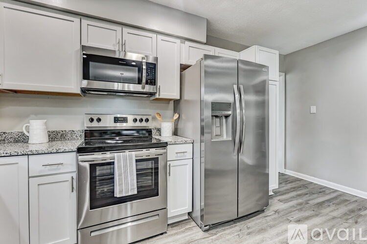 A modern kitchen with stainless steel appliances and white cabinets.