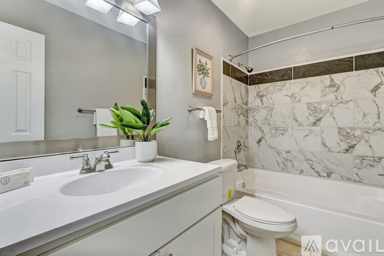 A bathroom with a marble tile wall and a white toilet.