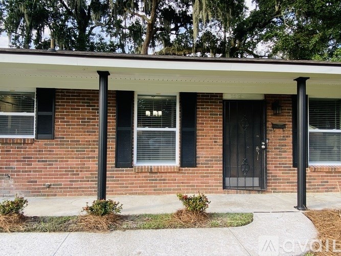 A red brick house with a black door and windows.