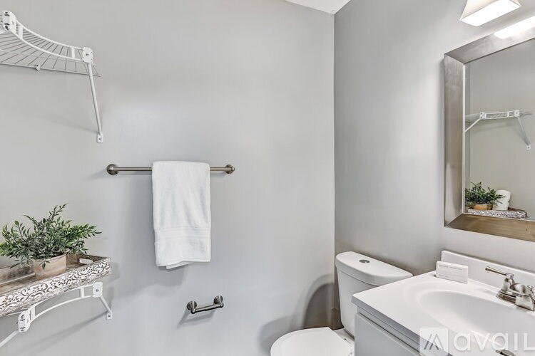 A white towel hangs on a towel rack in a bathroom.