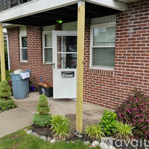 A small house with a white door and a mailbox on the front.