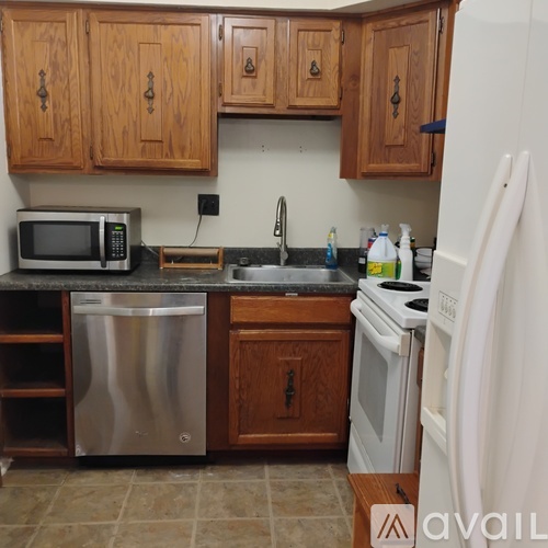 A kitchen with wooden cabinets and a white refrigerator.