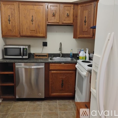A kitchen with wooden cabinets and a white refrigerator.