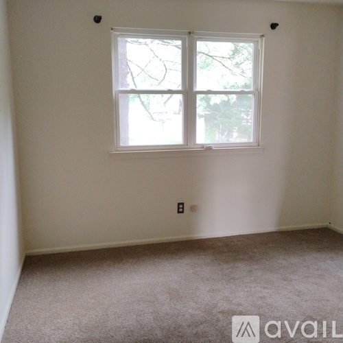 A room with a window and carpeted floor.