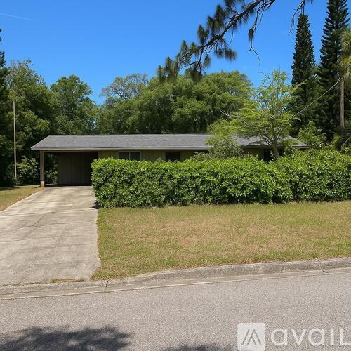 A house with a grey roof and a green hedge in front.