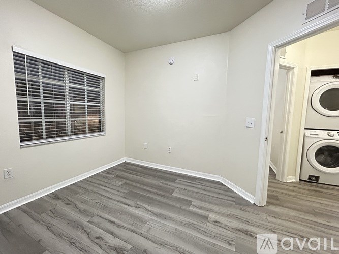 A room with a ceiling fan and a window with blinds.