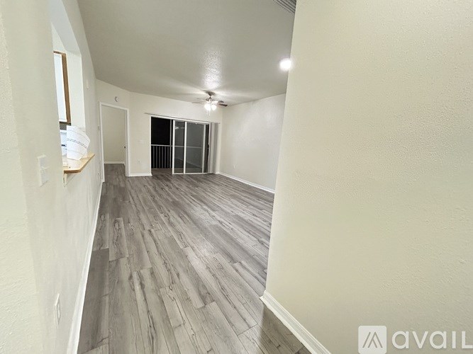 A room with wooden flooring and a window with blinds.