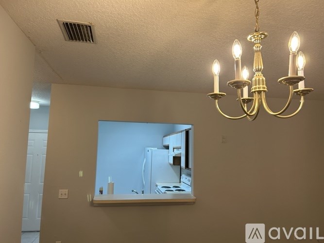 A chandelier hangs over a mirror in a room.