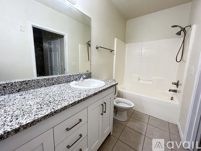 A bathroom with granite countertops and a walk-in shower.