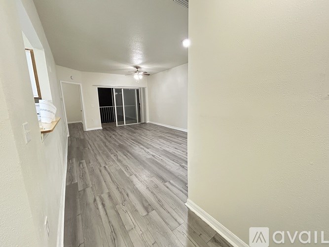 A room with wooden flooring and a window with blinds.