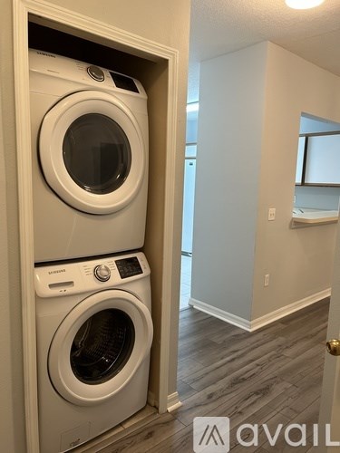 Two front loading washing machines in a wall-mounted cabinet.