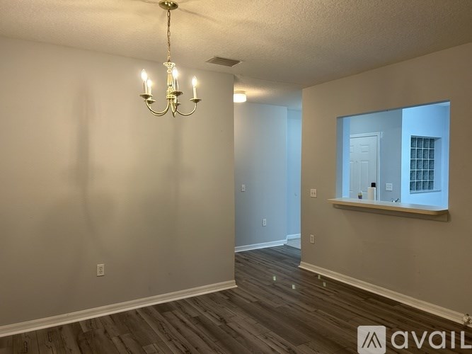 A room with a chandelier and a window with bars on it.