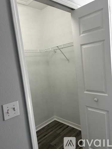 A white door with a white wall and a white shelf.