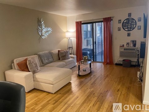 A living room with a white couch and a wooden floor.