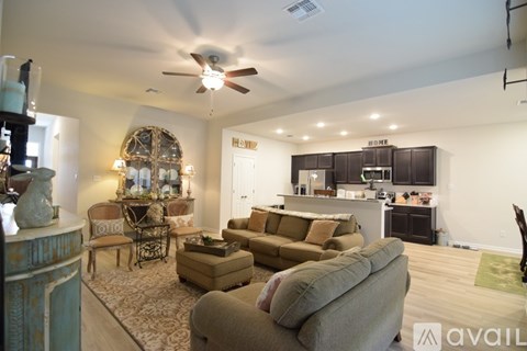 A living room with a couch, chair, and a table with a lamp on it.