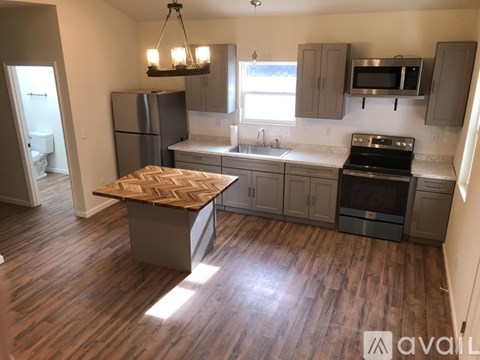 A kitchen with a wooden table and stainless steel appliances.