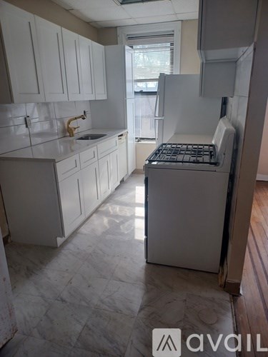 A kitchen with white cabinets and a white stove top oven.