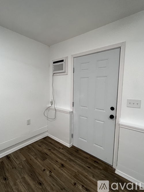 A white door with a black handle and a white wall with a white door.