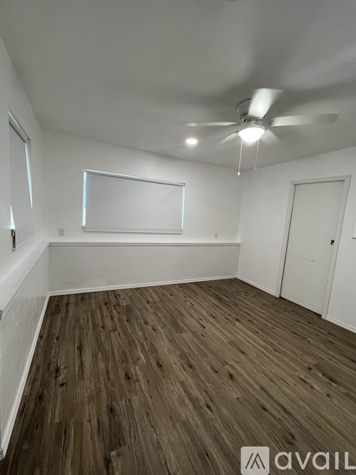 A room with wooden flooring and a ceiling fan.