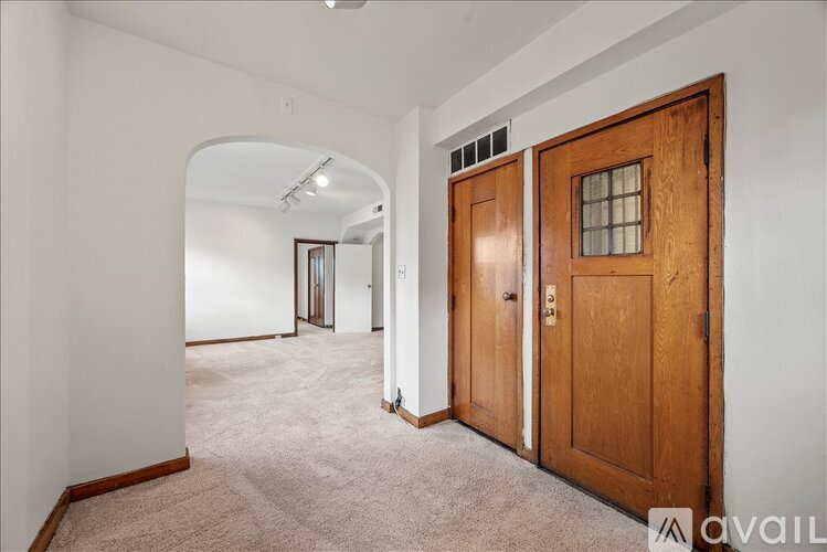 A room with a wooden door and carpeted floor.