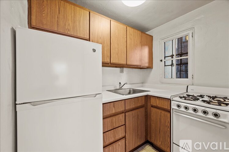 A kitchen with a white fridge, wooden cabinets, and a white stove.