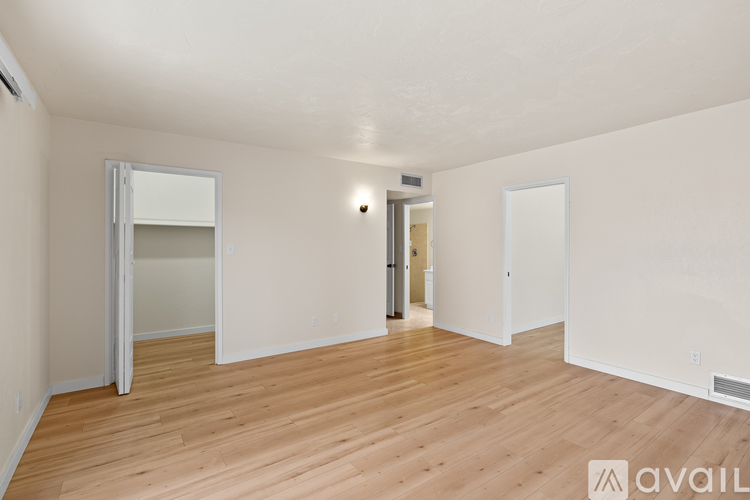 A spacious room with wooden floors and white walls.