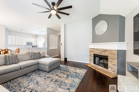 A living room with a grey couch and a fireplace.