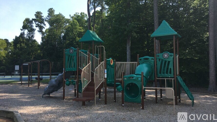 A playground with a green slide and a brown slide.