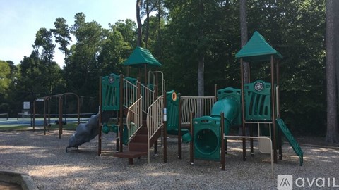 A playground with a green slide and a brown slide.