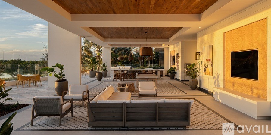 A modern living room with a wooden ceiling and a large grey sofa.