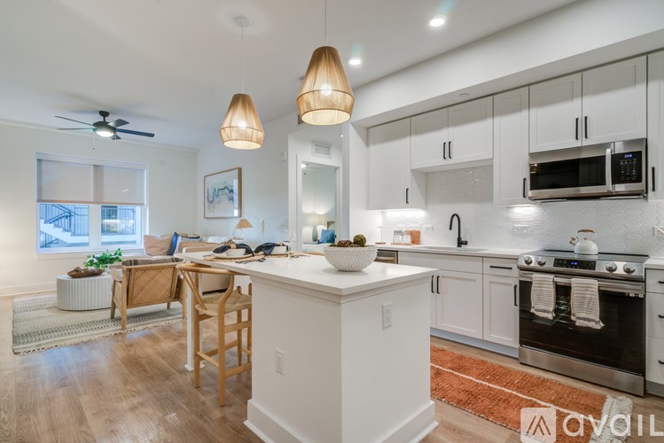 A kitchen with white cabinets and a wooden island.