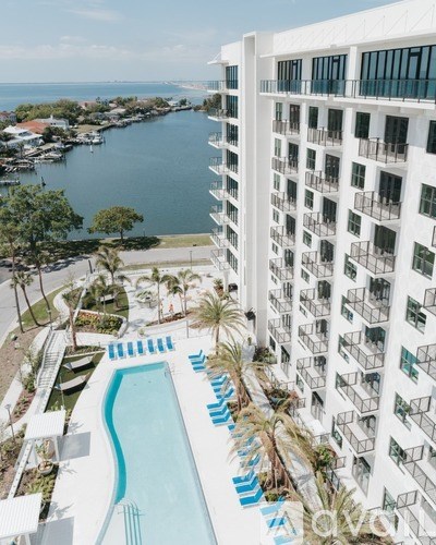 A white building with a pool in front of it.