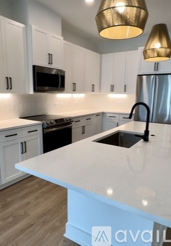 A kitchen with white cabinets and a white countertop.
